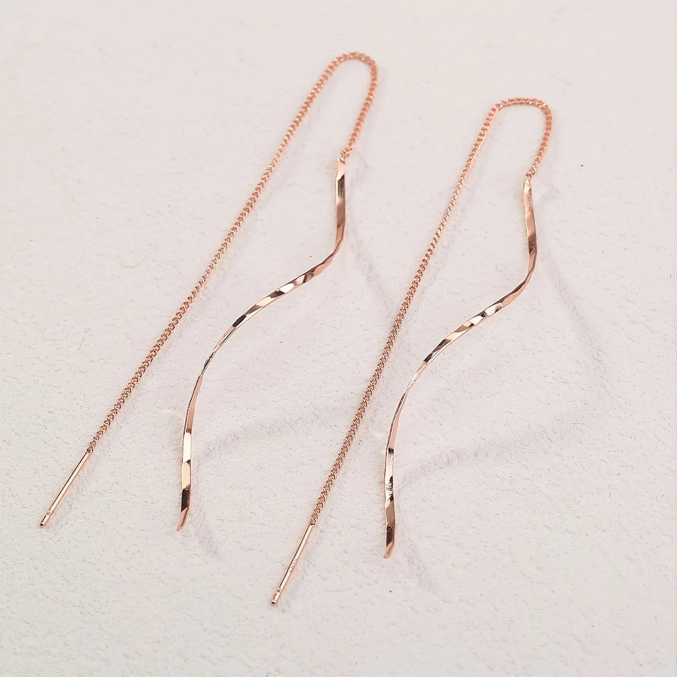 Minimalistische damesoorbel met golvende hanger en kettingdetail