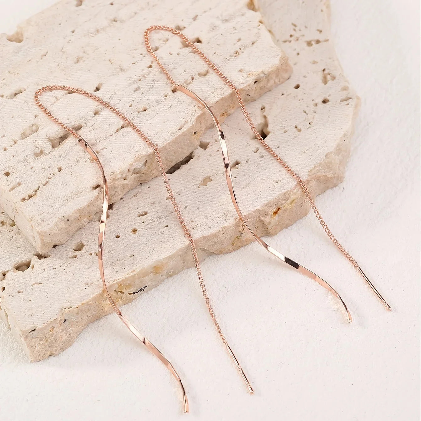Minimalistische damesoorbel met golvende hanger en kettingdetail