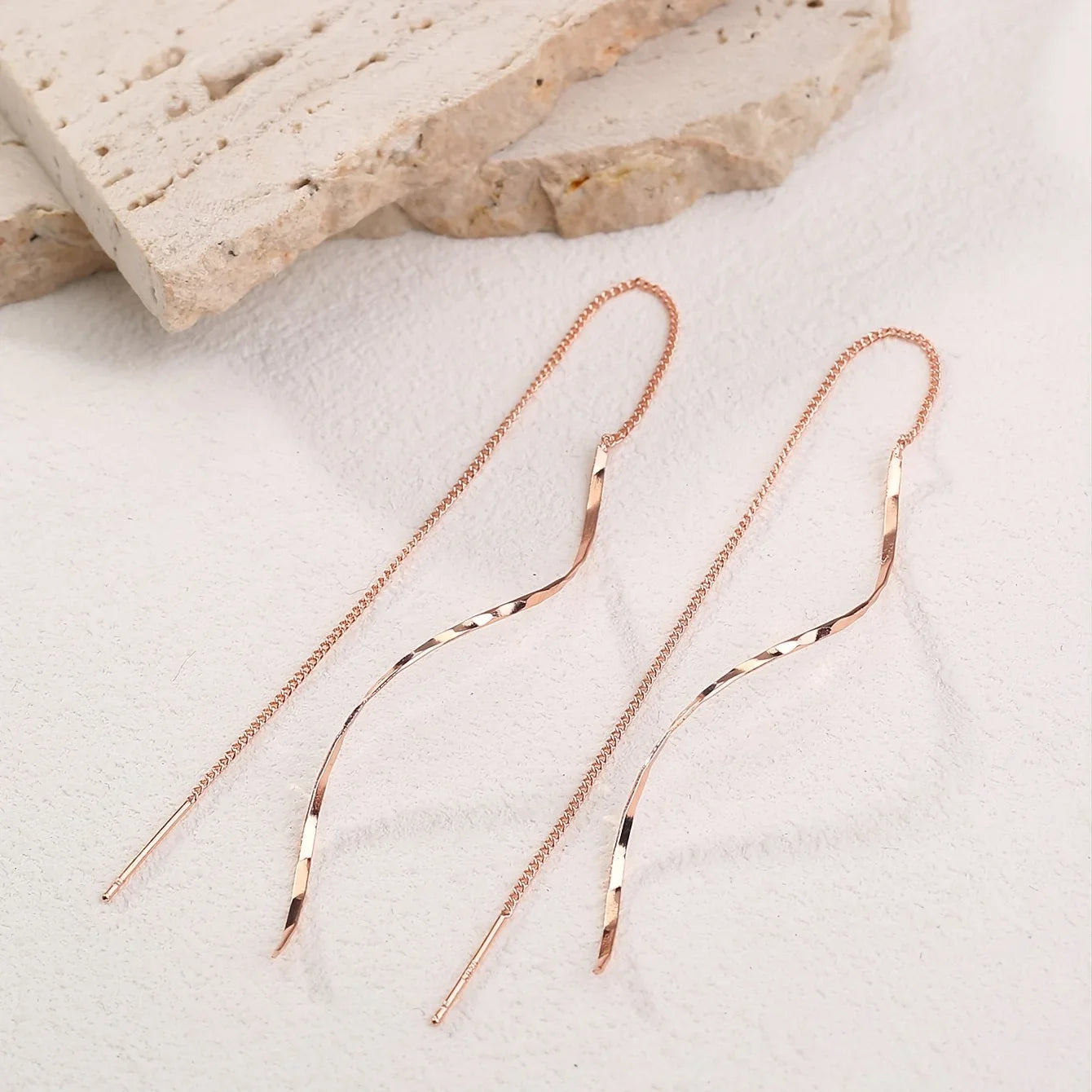 Minimalistische damesoorbel met golvende hanger en kettingdetail