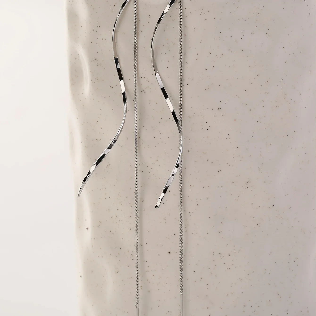 Minimalistische damesoorbel met golvende hanger en kettingdetail