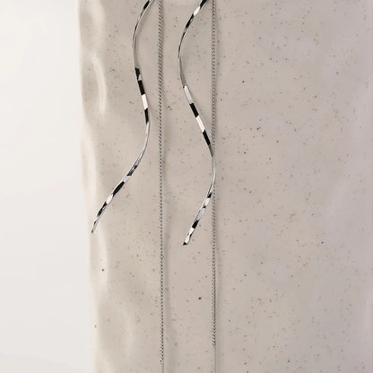 Minimalistische damesoorbel met golvende hanger en kettingdetail