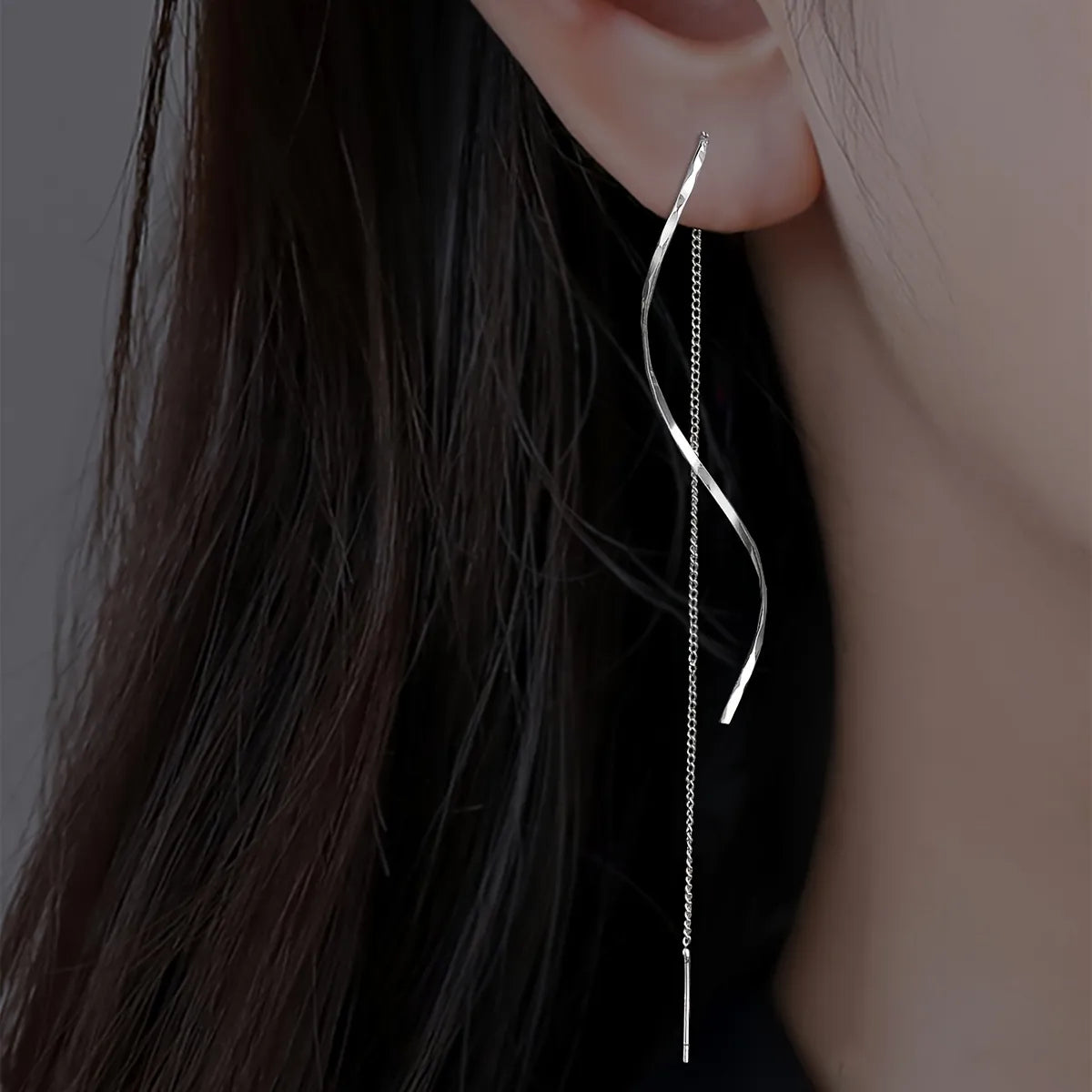 Minimalistische damesoorbel met golvende hanger en kettingdetail