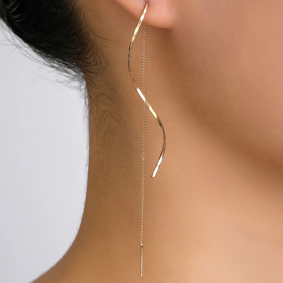 Minimalistische damesoorbel met golvende hanger en kettingdetail