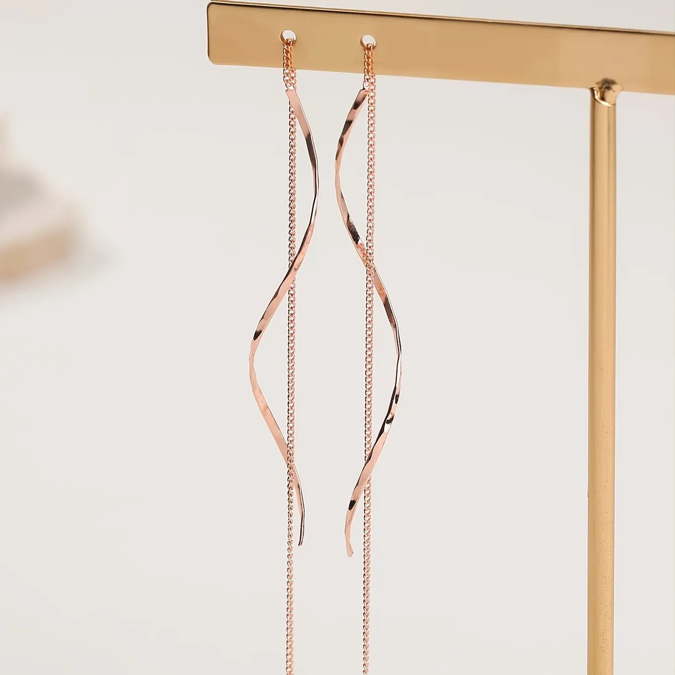 Minimalistische damesoorbel met golvende hanger en kettingdetail